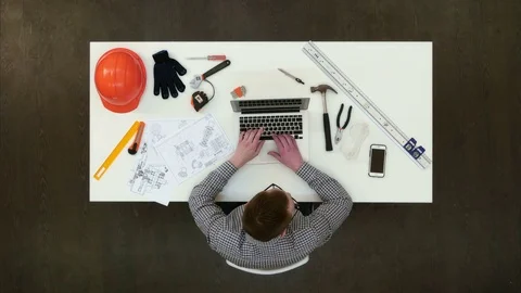 Architect in office working on laptop and answering phone call Stock Footage 71618600