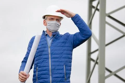 Architect or engineer with hard hat and face mask looking out  for something Stock Photos