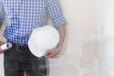 Architect or engineer man with blueprint and white safety helmet at office .. Stock Photos