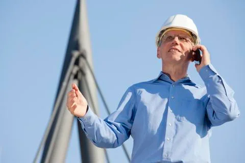 Architect or engineer talking on smart phone in front of an industrial buildi Stock Photos
