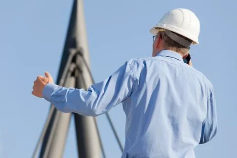 Architect or engineer talking on smart phone in front of an industrial buildi Stock Photos