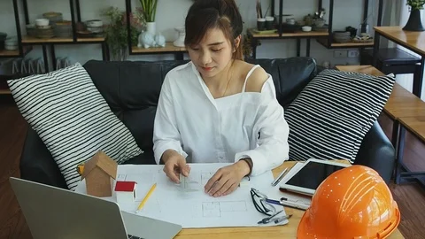 An architect or engineer uses a vernier to measure the size of a house model. Stock Footage 117843731