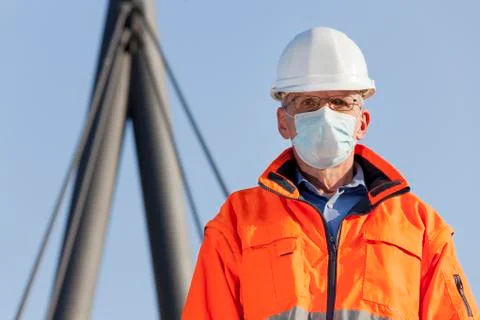 Architect or engineer wearing a face mask and protective clothing in front of Stock Photos
