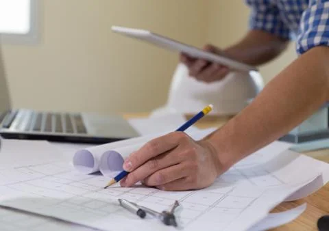 Architect or engineer working with blueprints and tablet in office, Constru.. Stock Photos