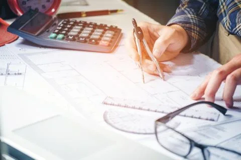 Architect or engineer working in office on blueprint. Architects workplace .. Stock Photos