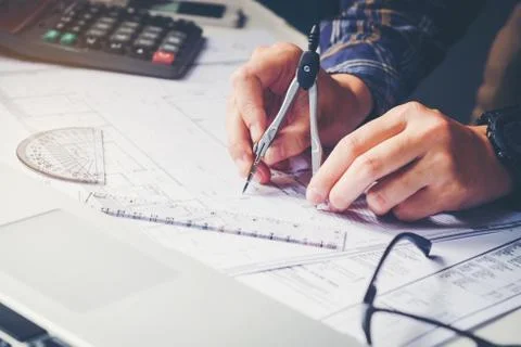 Architect or engineer working in office on blueprint. Architects workplace .. Stock Photos