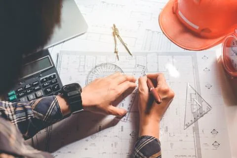 Architect or engineer working in office on blueprint. Architects workplace .. Stock Photos