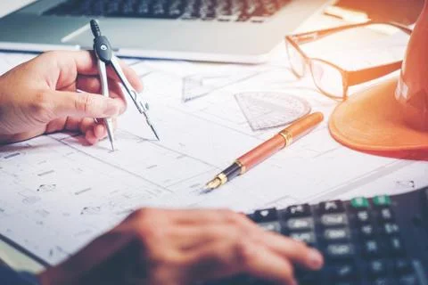 Architect or engineer working in office on blueprint. Architects workplace .. Stock Photos