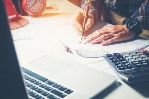 Architect or engineer working in office on blueprint. Architects workplace .. Stock Photos