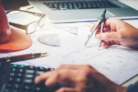 Architect or engineer working in office on blueprint. Architects workplace .. Stock Photos