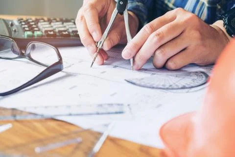 Architect or engineer working in office on blueprint. Architects workplace .. Stock Photos