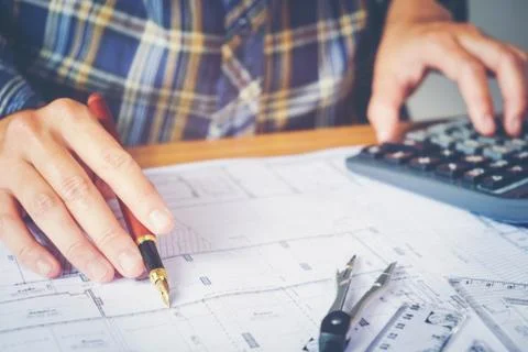 Architect or engineer working in office on blueprint. Architects workplace .. Stock Photos