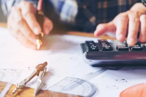 Architect or engineer working in office on blueprint. Architects workplace .. Stock Photos