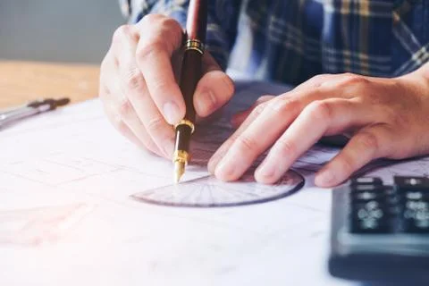 Architect or engineer working in office on blueprint. Architects workplace .. Stock Photos