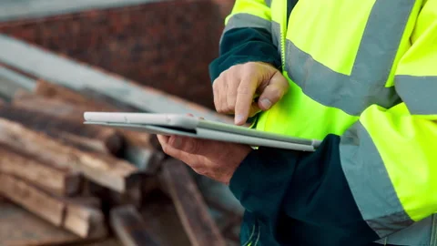 Architect, outdoor and hands with tablet at building site, search or safety Stock Footage 336189818