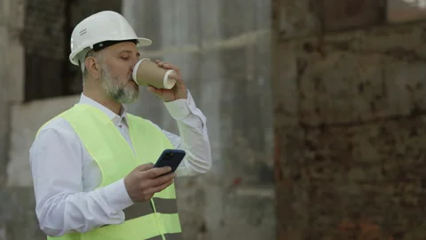 Architect with phone taking coffee break during walk outdoor Stock Footage 196180474