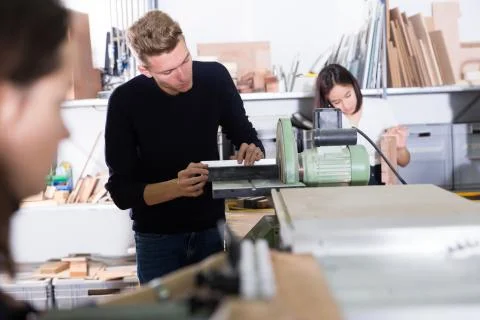 Architect polishing elements of model on sanding machine 库存照片
