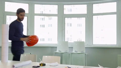 Architect puts hard hat on the desk Video stock 73912251
