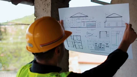 Architect Reading Blueprints Paperwork for Real Estate Stock-Footage 129444390