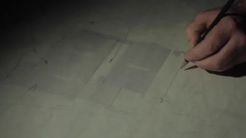 Architect scribbling on plans at night Stock Footage 142114643