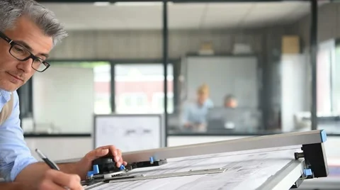 Architect sitting at drawing table in office Video stock 63360815