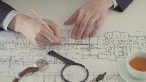 Architect sketching a construction project with pencil and ruler at work place Stock Footage 75058770