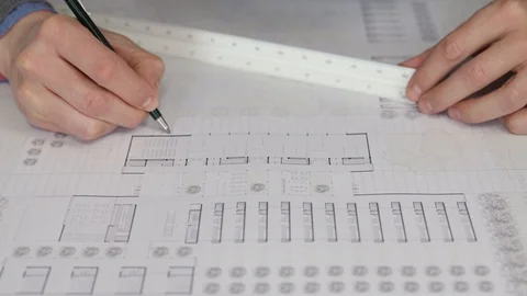 Architect taking measurements on a blueprint. 库存影片 125873069