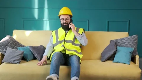 Architect talking on the phone and sitting on sofa to relax after a hard day. Stock Footage 156327952