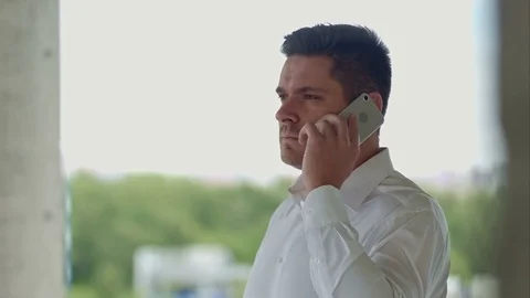 Architect talking by phone standing at construction site Видео 82800383