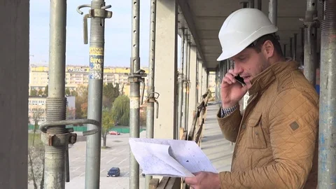 Architect talking by smarphone, browsing builiding project. 库存影片 72359794