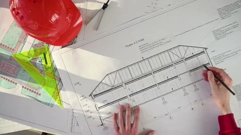 Architect unfolds building plan and marks it with pencil. Top view Stock Footage 143719641