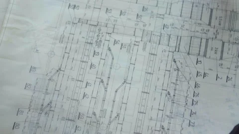 The architect unrolls and rotates the construction plans, blueprints so Stock Footage 173243679
