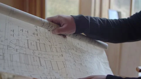 The architect unrolls design plans in his architectural studio. Stock Footage 173404718