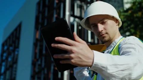 An architect uses a construction application on a digital tablet at a constructi Stockbeeldmateriaal 249262961