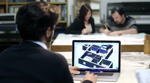 Architect using cad software: colleagues working on blueprints in background Stock Footage 49766855