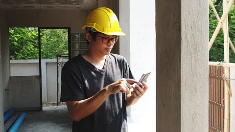 Architect using mobile phone beside the window in a house under construction. Stock Footage 92593637