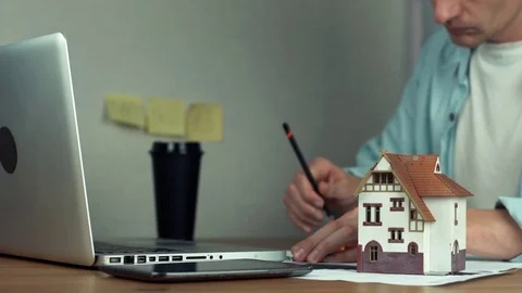 Architect using pencil and metal ruler creating housing project, drinking coffee Stock Footage 81881877