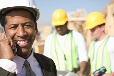 Architect Using Phone With Men In Background Stock Photos