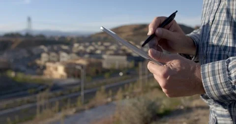 Architect using tablet computer in front of new construction 4K Stock Footage 84130281