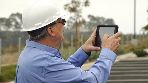 Architect using a tablet computer to take photos of a job site Stock Footage 121381140
