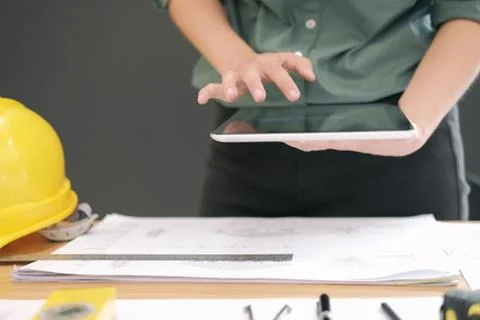 Architect using tablet. engineer working on house blueprint of real estate pr Stock Photos