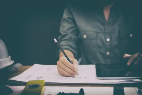 Architect using tablet. engineer working on house blueprint of real estate pr Stock Photos