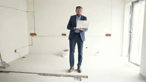 Architect walking in the new flat and checking project on notebook, steadycam sh Stock-Footage 95294003