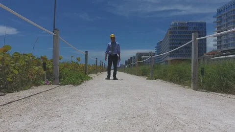 Architect walking on pathway next to construction site Stock Footage 70608803