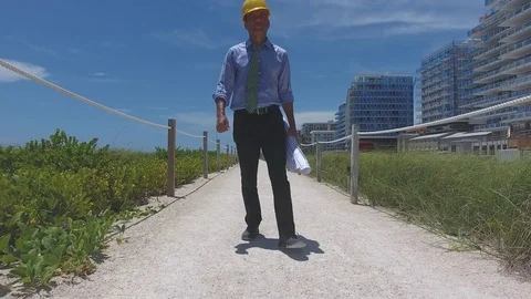 Architect walking on pathway next to construction site Stock Footage 70610748