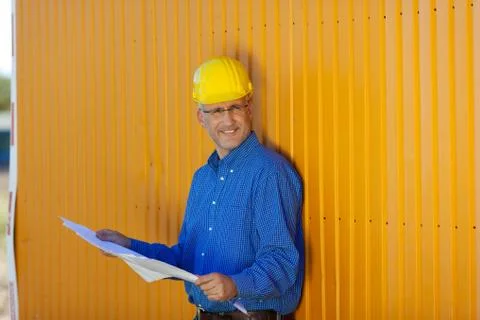 Architect wearing hardhat with blue print Stock Photos