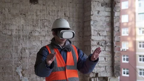 An architect wearing virtual reality glasses walks around a construction site. Stock Footage 263036553