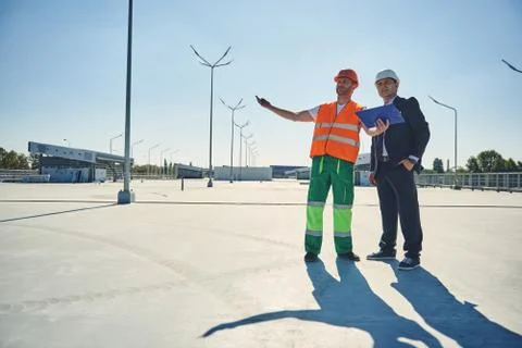 Architect with worker man are looking on facility Stock Photos