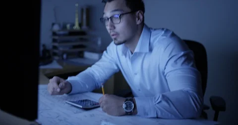 Architect working at his desk late at night Stock Footage 107643897
