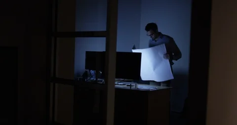 Architect working at his desk late at night Stock Footage 107644308